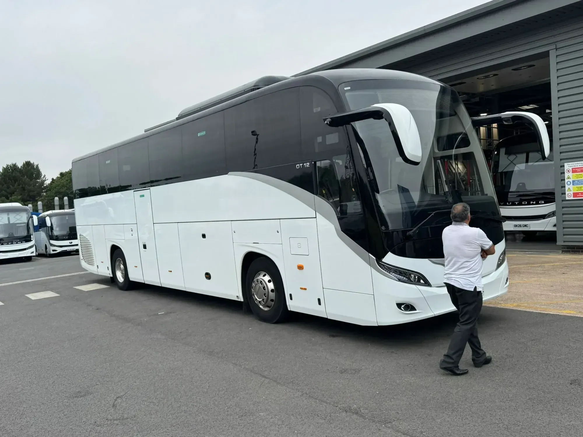 WMC coach photographed from the front three-quarter view with a member of staff nearby
